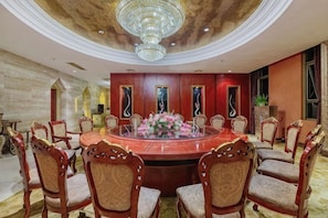 A round table with chairs, a chandelier, and a floral centerpiece. - Luban International Hotel (Nanling)
