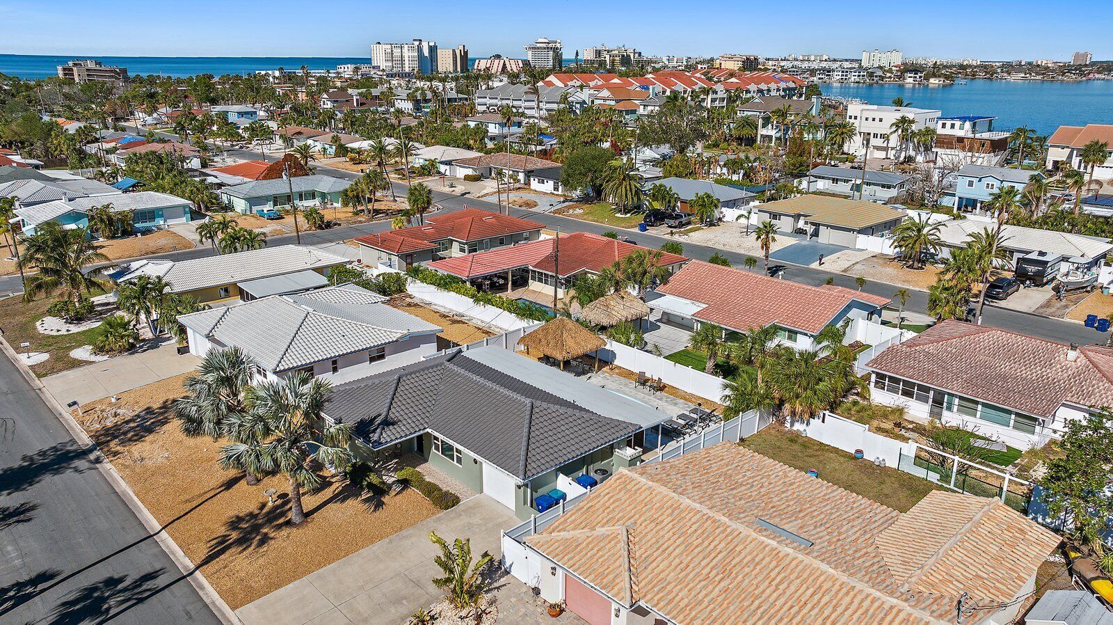 Zona residencial costera con casas, algunas con techos rojos, y vistas al océano.
