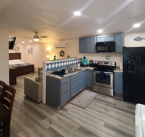 Una cocina moderna con armarios azules, un microondas, una estufa y un refrigerador.
