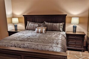 Quarto com uma cama grande, duas mesas de cabeceira e uma cômoda com gavetas.