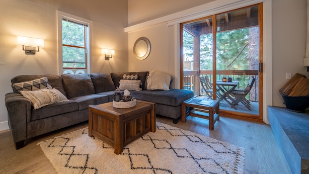 A living room with a sectional sofa, a coffee table, and a dining area with a table and chairs. - Cozy mountain hideaway for hikers, skiers and chefs! (Truckee)