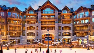 A multi-story hotel with balconies, a central courtyard, and a ski lift visible.