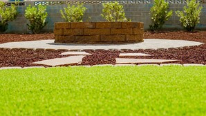 A landscaped garden with a circular brick planter, a paved walkway, and a well-maintained lawn. - Comfortable Desert Get-Away  (Yuma)