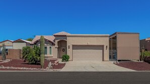 A single-story house with a garage, a small front yard with landscaping, and a clear blue sky. - Comfortable Desert Get-Away  (Yuma)