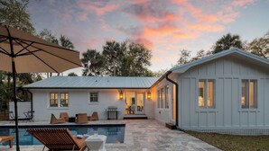 A house with a swimming pool, outdoor furniture, and a covered patio area. - Sawyer by Avantstay Stunning Isle Of Palms Home w/ Pool! (Isle of Palms)