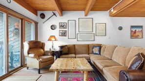 A cozy living room with a leather armchair, a wooden coffee table, and a large L-shaped sofa. - Riverside Condos B101 by Avantstay Condo Close To Downtown, Town Park & Ski Lift #8 (Telluride)