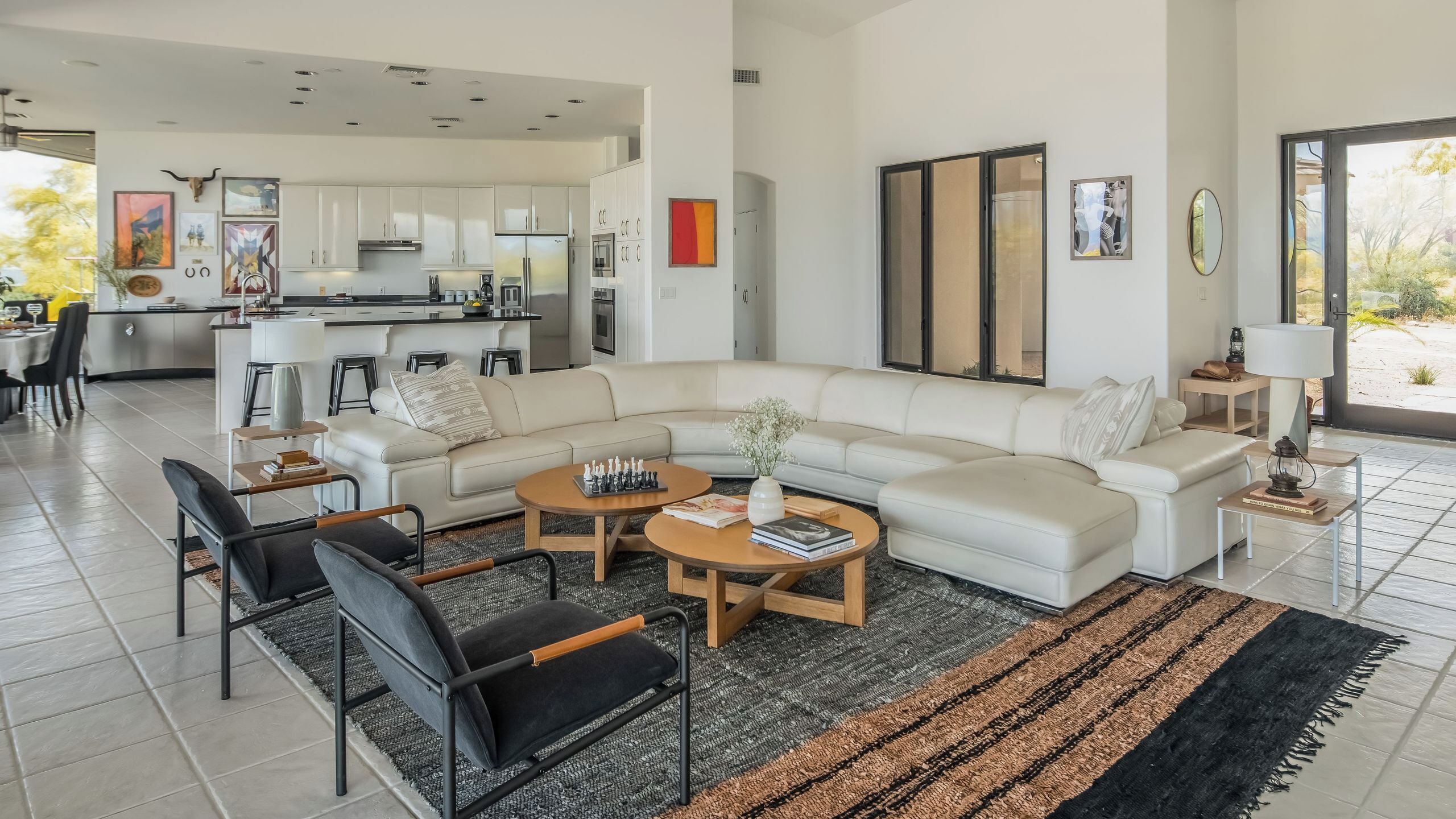 A modern living room with a sectional sofa, a coffee table, and a dining area with chairs.