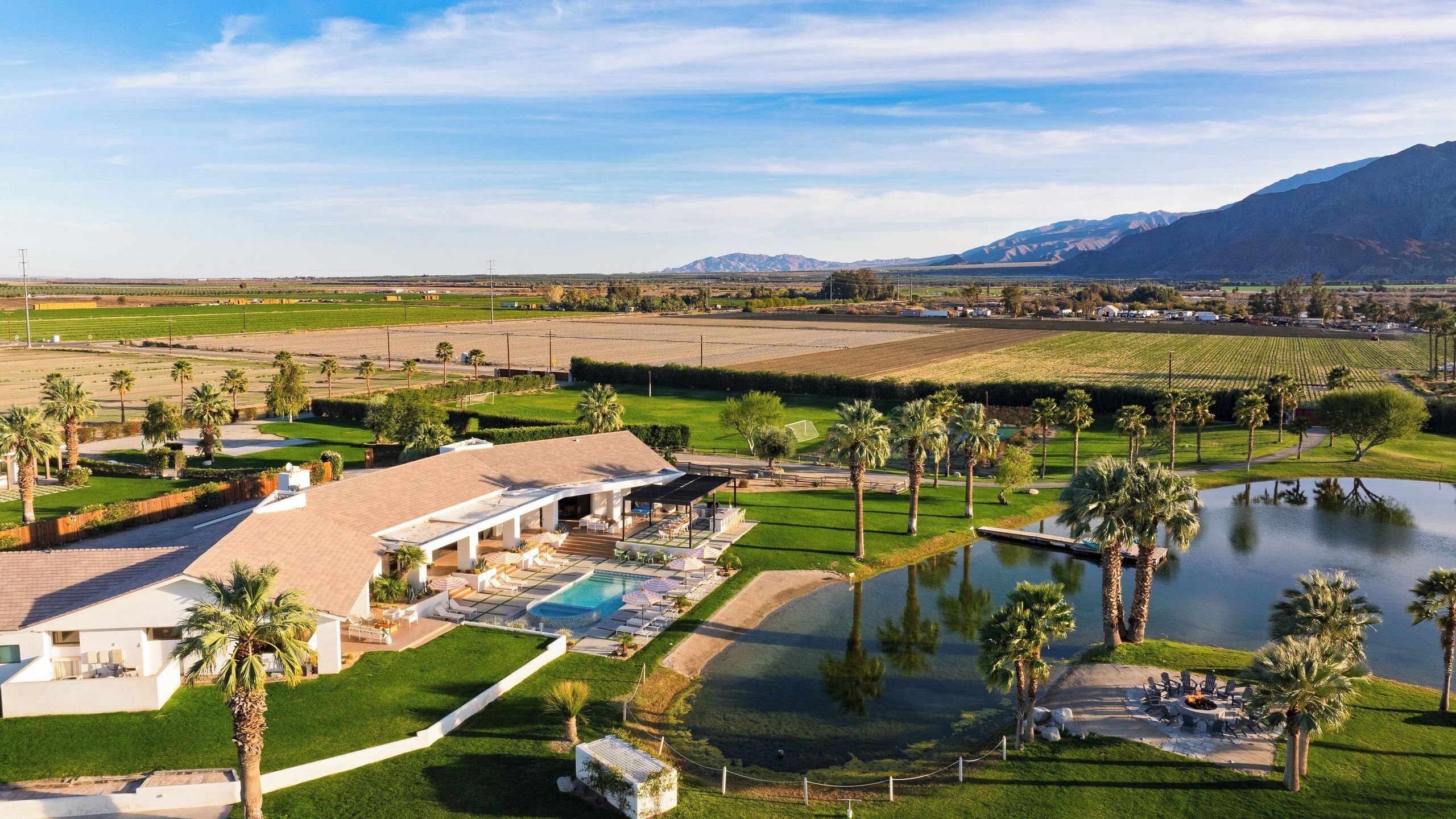 A resort with a swimming pool, outdoor seating, and a view of the surrounding landscape.