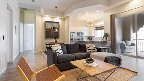A spacious living area with a sofa, coffee table, and a dining table. There is a kitchen in the background with modern appliances. - Eucalyptus by Avantstay Stunning Scottsdale Home w/ Communal Pool & Hot Tub (Scottsdale)