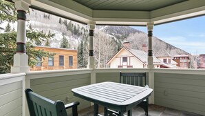 A covered patio with a table and chairs, a view of a mountain, and a building labeled "Telluride". - Legacy House by Avantstay Beautiful 4bdr Home in Great Location w/ Hot Tub (Telluride)
