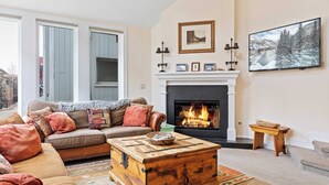 A cozy living room with a fireplace, a sofa, and a coffee table. - Legacy House by Avantstay Beautiful 4bdr Home in Great Location w/ Hot Tub (Telluride)
