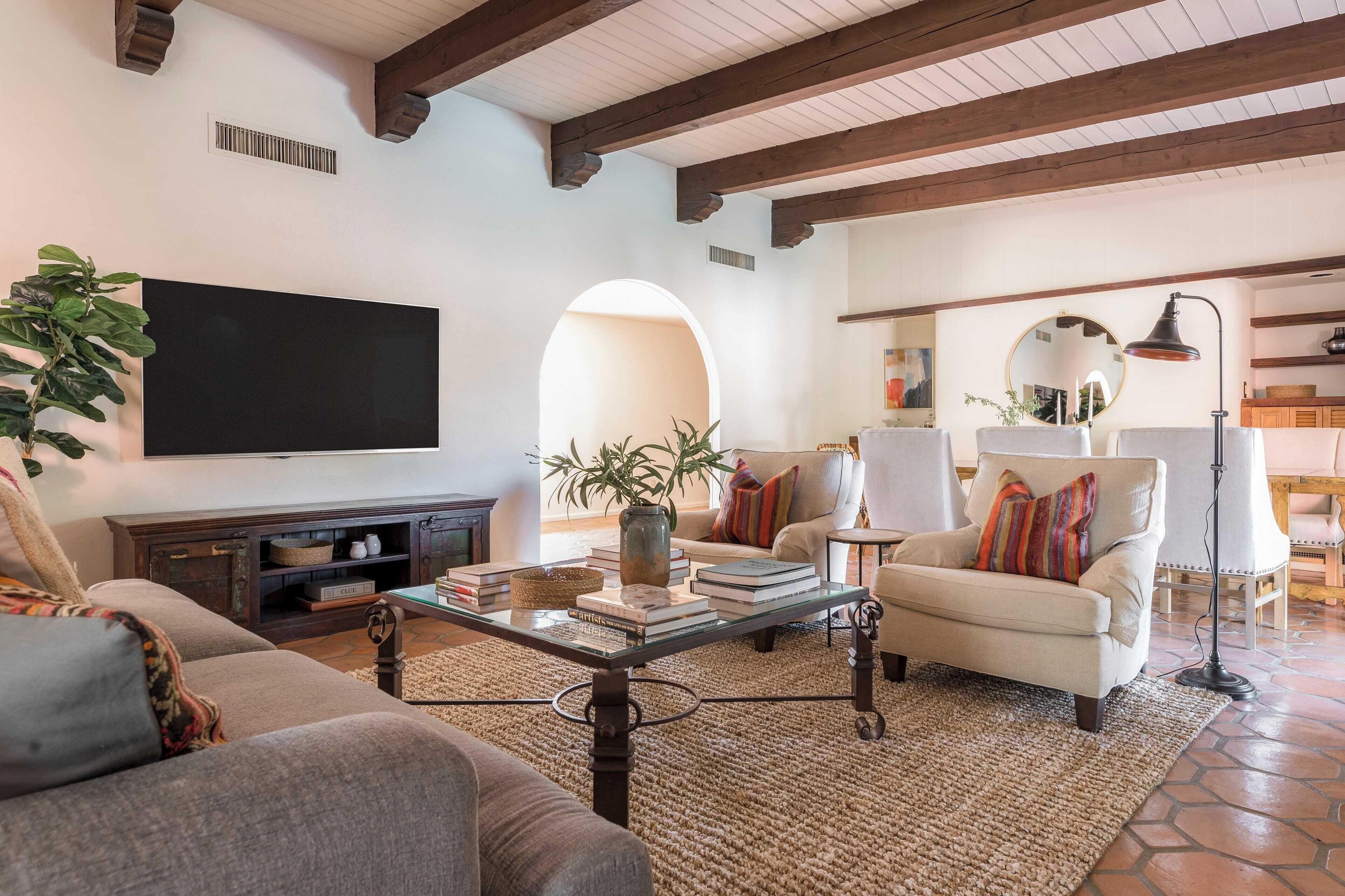 A living room with a flat-screen TV, a sofa, a coffee table, and a fireplace.