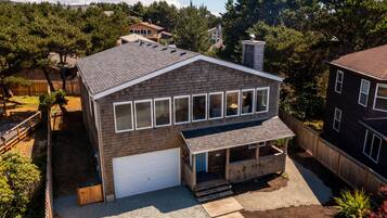 A two-story house with a garage, a covered porch, and a fenced yard.