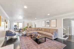 Relax in this inviting living space with a large L-shaped sofa, coffee table, and cozy armchair.