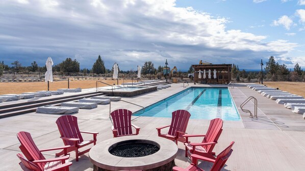 A pool area with red Adirondack chairs, a fire pit, and a view of the surrounding landscape. - Pioneer by Avantstay Magnificent Home Located In The Brasada Ranch Community! (Powell Butte)