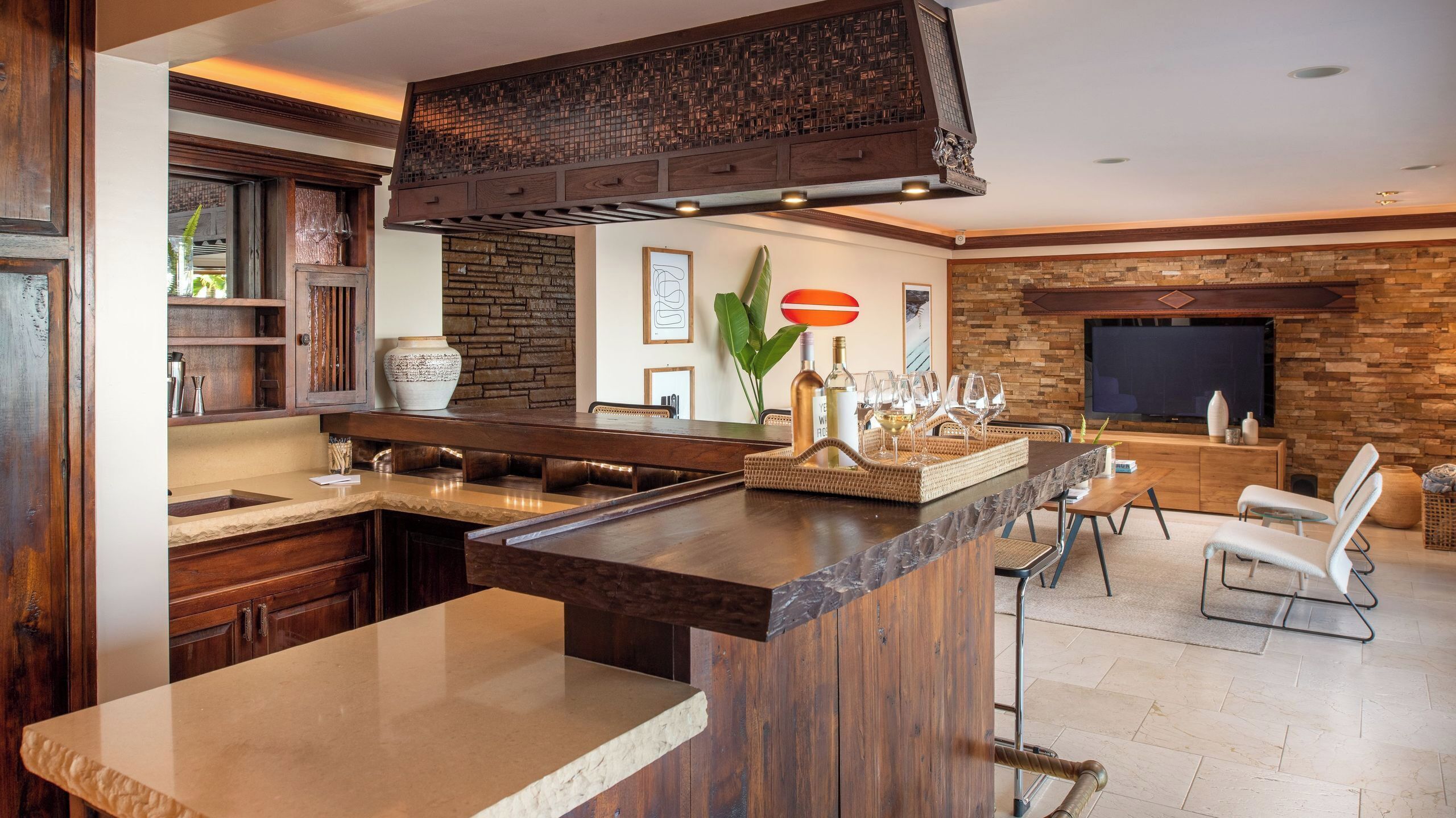A modern kitchen with a stone backsplash, wooden cabinets, and a large island.