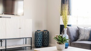 Ein modernes Wohnzimmer mit einem weißen Sofa, einem Couchtisch und dekorativen Vasen.