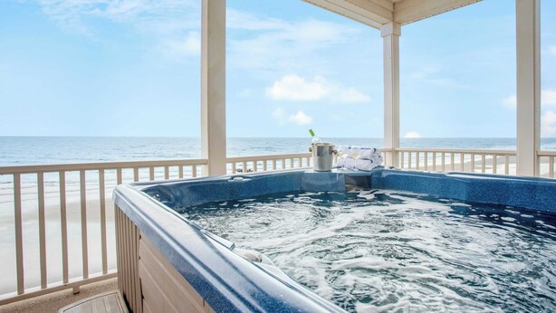 A hot tub with a view of the ocean, a beach, and a covered deck area. - Poseidon By Avantstay On The Beach! Two Ocean Facing Balconies & Hot Tub (Folly Beach)