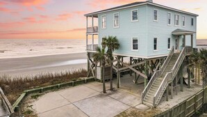 A light blue house with a balcony and a staircase on stilts, located near a beach. - Poseidon By Avantstay On The Beach! Two Ocean Facing Balconies & Hot Tub (Folly Beach)