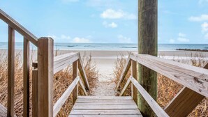 A wooden boardwalk leading to a beach with a clear sky. - Poseidon By Avantstay On The Beach! Two Ocean Facing Balconies & Hot Tub (Folly Beach)