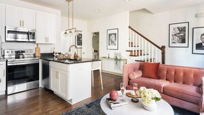 A modern kitchen with white cabinetry, stainless steel appliances, and a central island. - Hart Suite 16 by Avantstay Gorgeous Town House w/ Modern Amenities in Nashville! (Nashville)