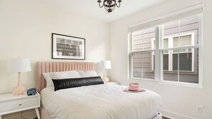 A bedroom with a bed, bedside tables, a window, and a chandelier. - Hart Suite 16 by Avantstay Gorgeous Town House w/ Modern Amenities in Nashville! (Nashville)