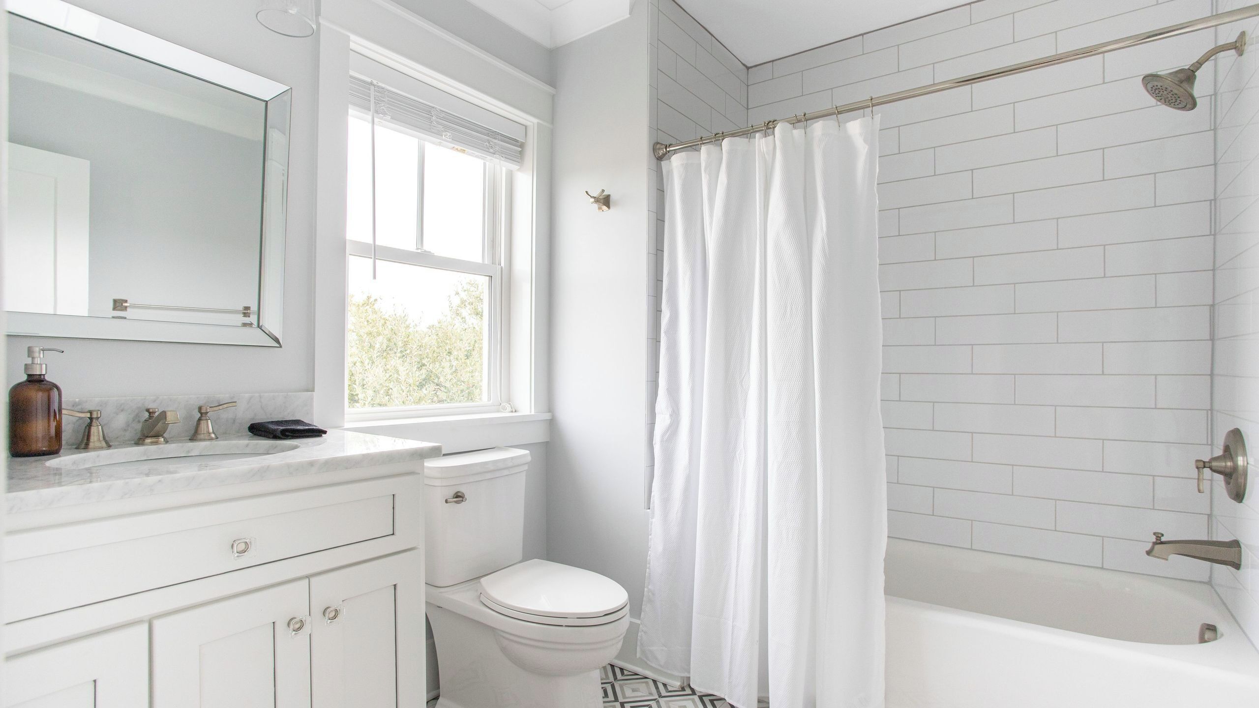 A bathroom with a white toilet, a sink with a mirror, and a shower area with a curtain.
