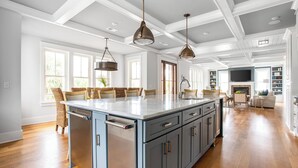 A spacious kitchen with a large island, pendant lighting, and a view to the living area. - 1blck to Beach, Pool, Outdoor Kitchen, Game Room Pelican by Avantstay (Isle of Palms)