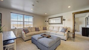 A living room with a sectional sofa, a coffee table, a dining table, and a large window with blinds. - Resort Plaza #5061 by Avantstay Located in Park City Mountain Resort Close to the Slopes! (Park City)