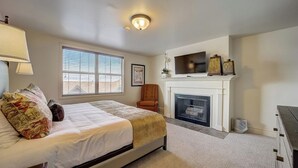 A bedroom with a bed, a chair, a fireplace, and a TV. - Resort Plaza #5061 by Avantstay Located in Park City Mountain Resort Close to the Slopes! (Park City)