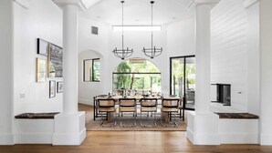A spacious dining area with a large table, multiple chairs, and a modern chandelier. - Villa Verbena by Avantstay Expansive Estate w/ B-ball Court, Pool/spa & Entertainer's Yard (Indio)