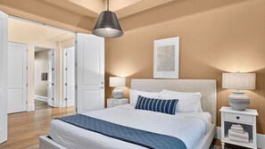 Une chambre à coucher avec un grand lit, des lampes de chevet, une table de chevet et un luminaire suspendu.