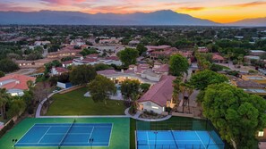 Zona residencial con varias casas, una cancha de tenis y una piscina.