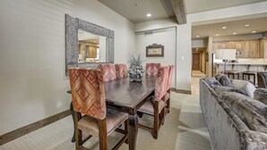 A dining area with a wooden table and patterned chairs, a large mirror, and a framed picture on the wall. - Mont Cervin by Avantstay Private Hot Tub + Fireplace Walk to Ski-in/ski-out + Dining (Park City)