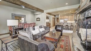 A spacious living room with a sofa, coffee table, and a fireplace. - Mont Cervin by Avantstay Private Hot Tub + Fireplace Walk to Ski-in/ski-out + Dining (Park City)