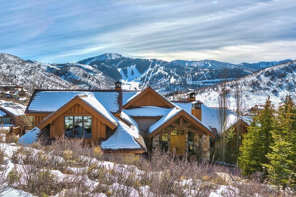 A wooden lodge with multiple cabins, set against a backdrop of snow-covered mountains and a clear sky. - Telemark Luxury Retreat by Avantstay Stunning Views w/ Hot Tub, Theatre Room and Pool Table! (Park City)