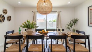 A dining area with a round table, six chairs, a potted plant, a fruit bowl, and a hanging light fixture. - Rosario by Avantstay10mins to Old Town Scottsdale (Scottsdale)