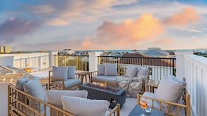 A rooftop terrace with outdoor seating, a fire feature, and a view of the cityscape. - Rendezvous by Avantstay Modern Haven w/ Game Room, Roof Top, Pool & Close to Beach! (Miramar Beach)