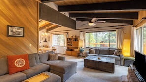A cozy living room with a sofa, ottoman, coffee table, and a ceiling fan. - Fawn by Avantstay Secluded Cabin w/ Large Deck Surrounded by Forest (Tahoma)