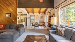 A cozy living room with a sofa, coffee table, and a dining area with chairs and a table.