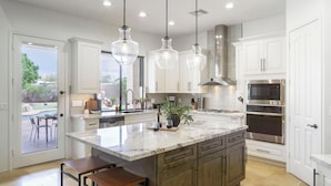 A modern kitchen with a marble island, stainless steel appliances, and pendant lighting. - Arcadia by Avantstay Breathtaking Oasis in Scottsdale w/ Pool, Hot Tub & Game Room (Scottsdale)