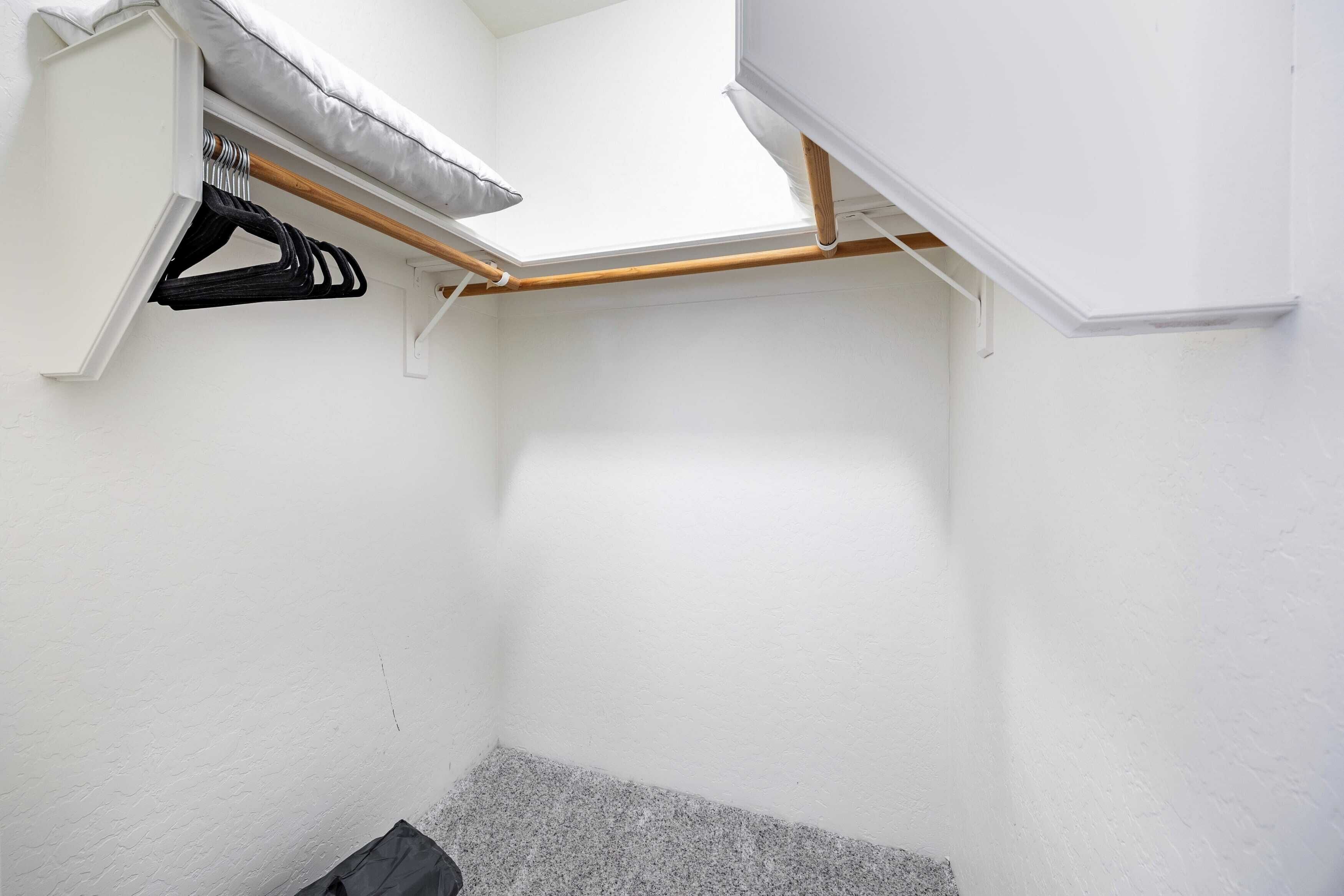 A compact room with a skylight, a built-in bench with a pillow, and a wooden beam overhead.