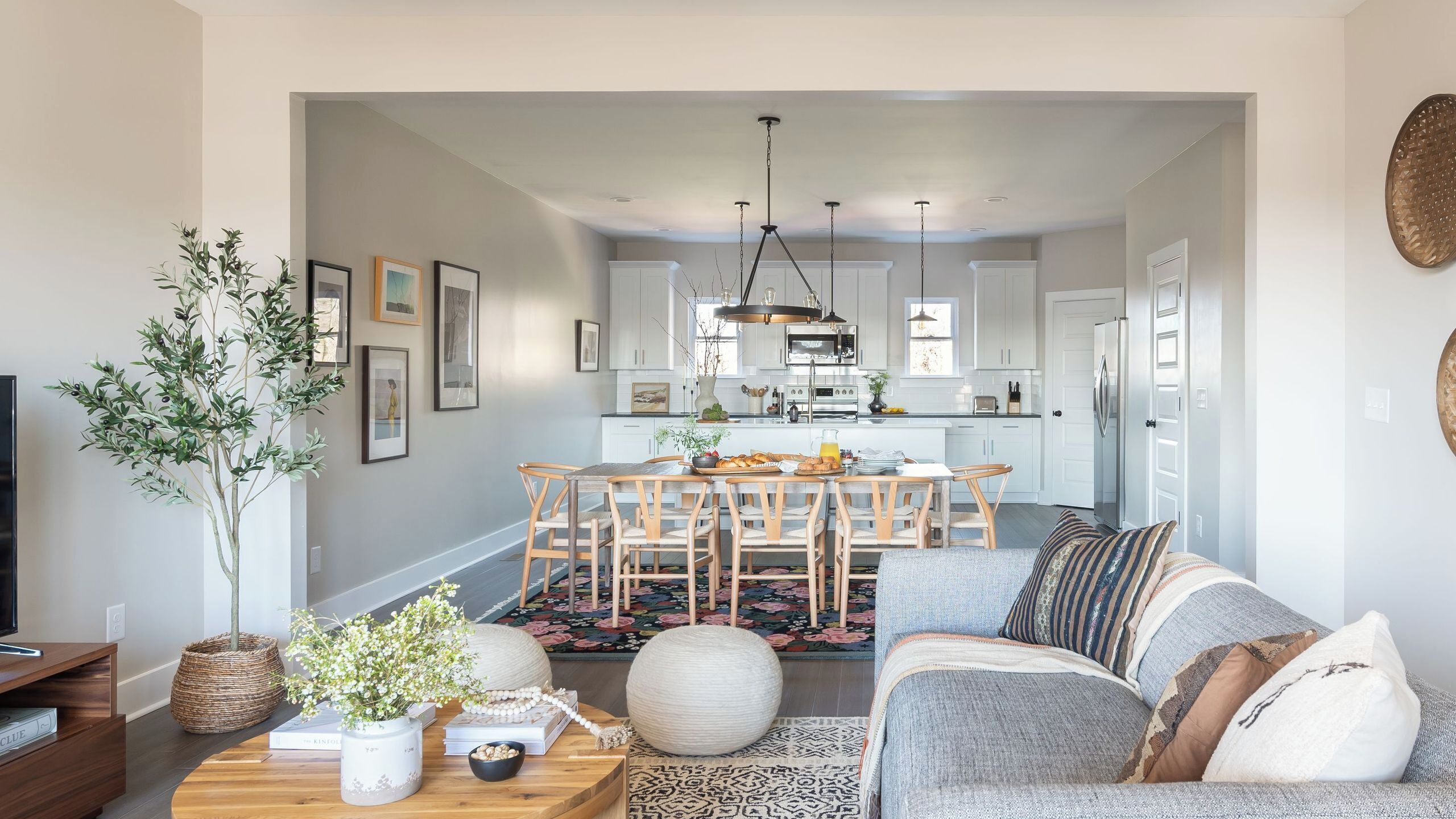 Un salon moderne comprenant un canapé, une table basse et un coin repas avec des chaises et une table.