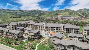 A residential area with modern multi-story buildings, a swimming pool, and a mountainous backdrop. - Kokopelli by Avantstay Close to the Ski Slopes in This Majestic Home in Park City (Park City)