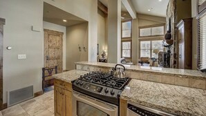A kitchen with a granite countertop, stainless steel appliances, and wooden cabinets. - Mont Cervin #33 by Avantstay Luxury Ski in Ski out Home in Park City! (Park City)