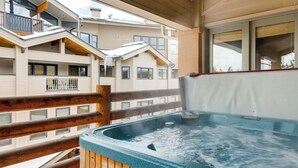 A hot tub on a balcony with wooden railings, a view of neighboring buildings, and a clear sky. - Mont Cervin #33 by Avantstay Luxury Ski in Ski out Home in Park City! (Park City)