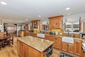 A spacious kitchen with wooden cabinets, granite countertops, and a large island. - Lakefront Estate w/ Private Dock, Hottub, Firepit Lagunita Shores by Avantstay (Big Bear Lake)