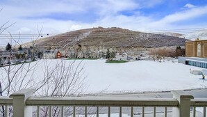 Un paisaje nevado con una colina, casas y un edificio de fachada de ladrillo.