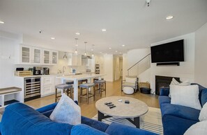 A modern living room with a blue sofa, a coffee table, and a TV mounted on the wall. - Powder Ridge Skier's Retreat by Avantstay Large Modern Home Close to Park City Resort w/ Views (Park City)