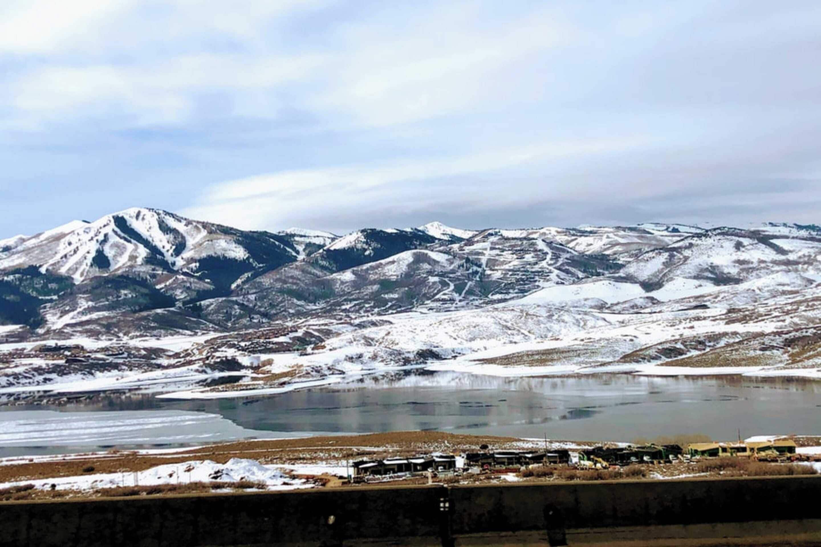 A mountainous landscape with a lake and a small settlement.